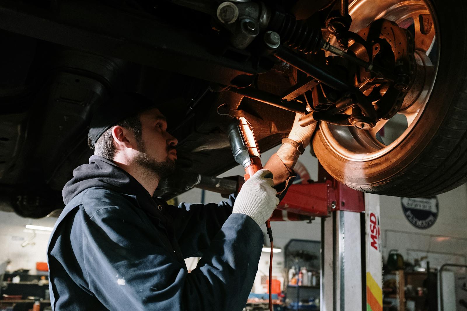 Werkstatt mit erhöhtem Fahrzeug auf der Hebebühne